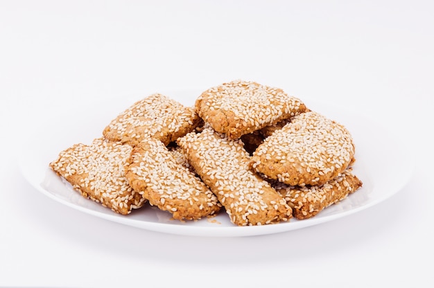 Sur une assiette blanche, sur un fond blanc des biscuits frais au sésame.