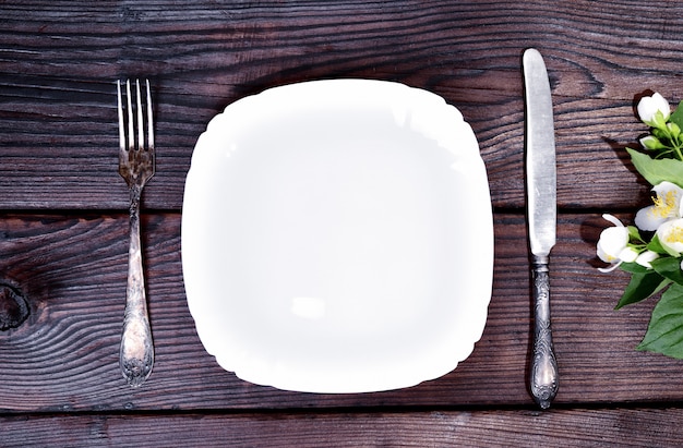 Assiette blanche avec une fourchette et un couteau