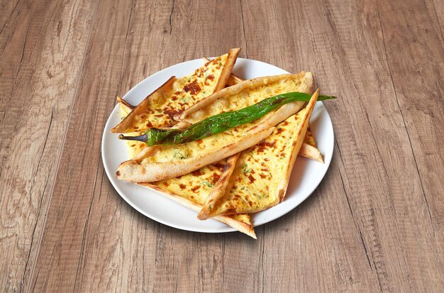 Photo assiette blanche avec fromage feta pide et légumes sur table en bois