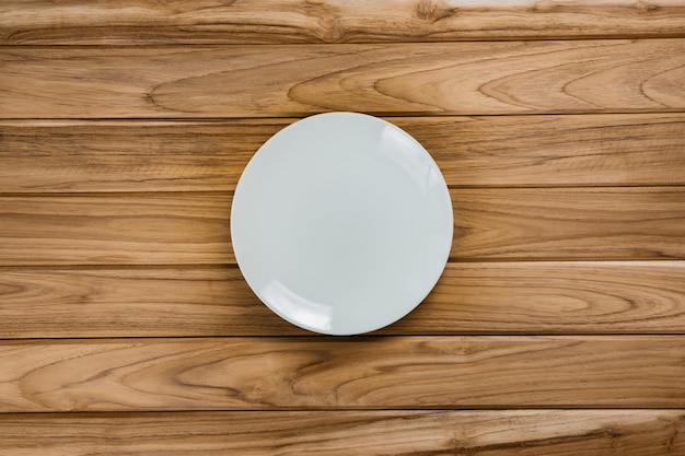 Une assiette blanche repose sur une table en bois