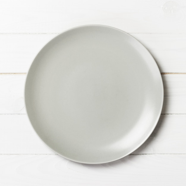 Assiette blanche vide sur bois