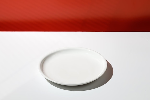 Assiette blanche vide pour la nourriture Fond minimal pour la présentation du produit Scène Mur rouge blanc D