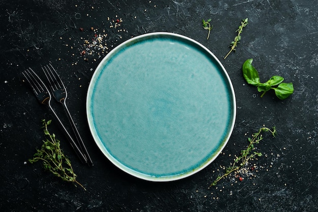 Assiette bleue avec légumes et épices sur fond de pierre noire Vue de dessus Style rustique