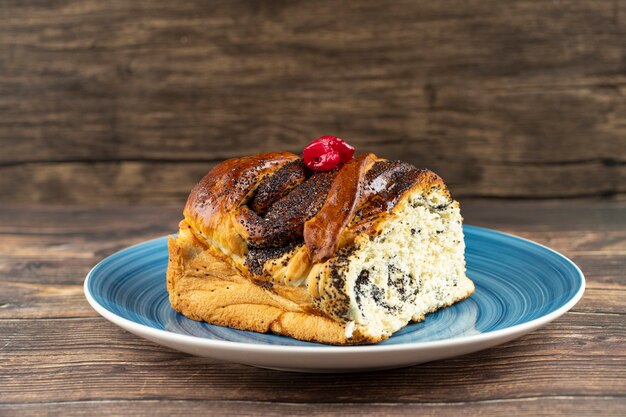 Assiette bleue de pâtisserie fraîche avec sauce au chocolat sur table en bois.