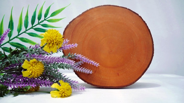 Une assiette en bois avec un arrangement floral à côté