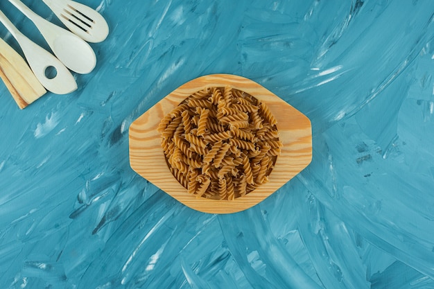 Assiette en bois de fusilli sec brut sur surface en marbre