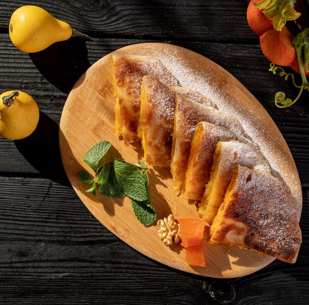 Une assiette en bois avec un morceau de pain avec une feuille verte dessus.