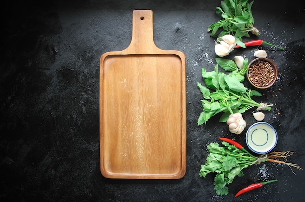 Assiette en bois vide sur culinaire en métal noir