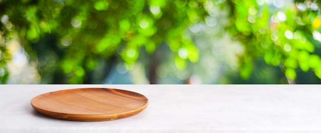 Assiette en bois vide sur tableau blanc sur la nature des arbres verts flous avec fond bokeh