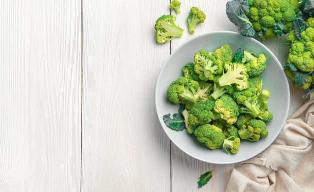 Une assiette de brocoli sur un fond de bois blanc