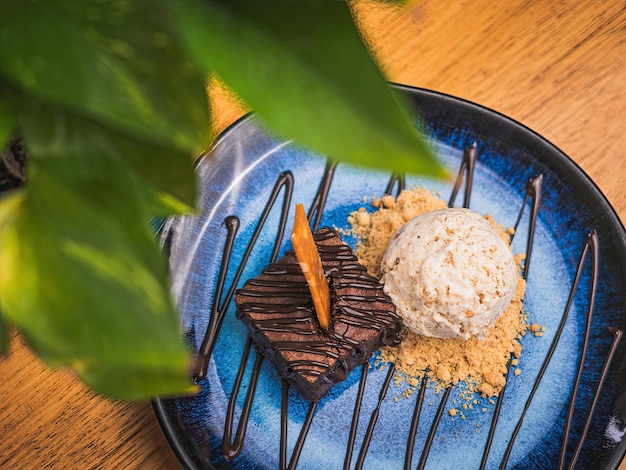 Une assiette de brownies au chocolat avec une boule de glace à la vanille dessus