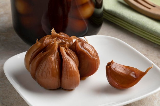 Assiette avec un bulbe d'ail mariné et une gousse