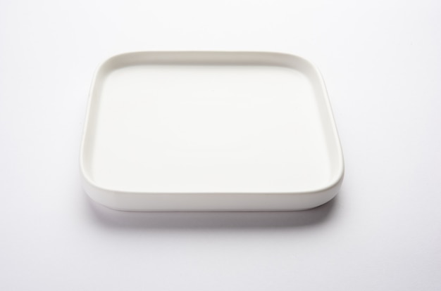 Assiette carrée en céramique blanche vide isolée sur une surface blanche