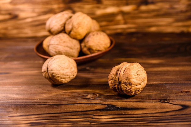 Assiette en céramique aux noix sur table en bois rustique