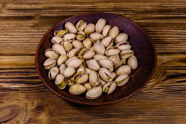 Assiette en céramique aux pistaches sur une table en bois