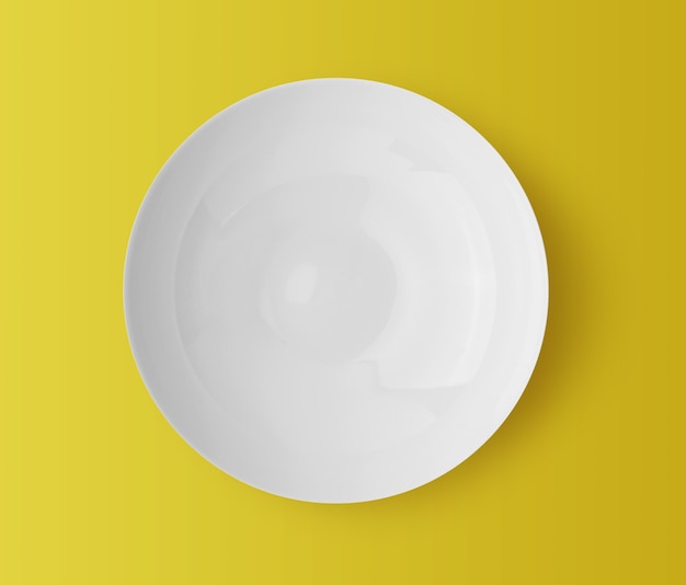 Assiette en céramique blanche sur fond jaune