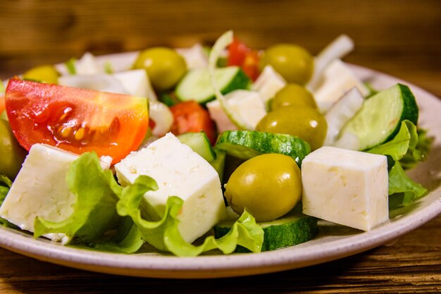 Assiette en céramique avec salade grecque sur table en bois rustique