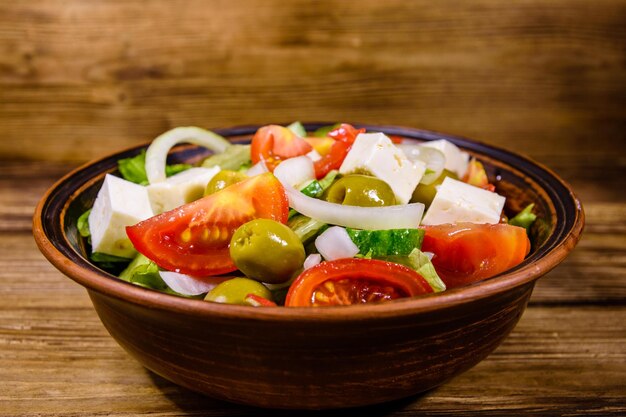 Assiette en céramique avec salade grecque sur table en bois rustique