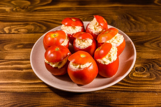 Assiette en céramique avec tomates farcies sur table en bois rustique