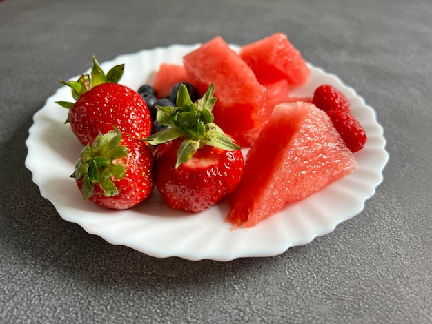 Une assiette avec une collation printanière sous forme de fruits