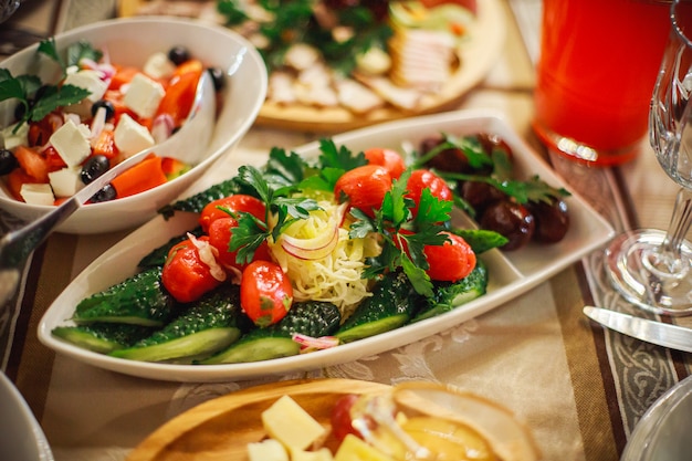 Assiette de cornichons - salé, tomates salées, cornichons, oignons corned et garni de persil. Apéritifs froids dans le restaurant au banquet en l'honneur des vacances.