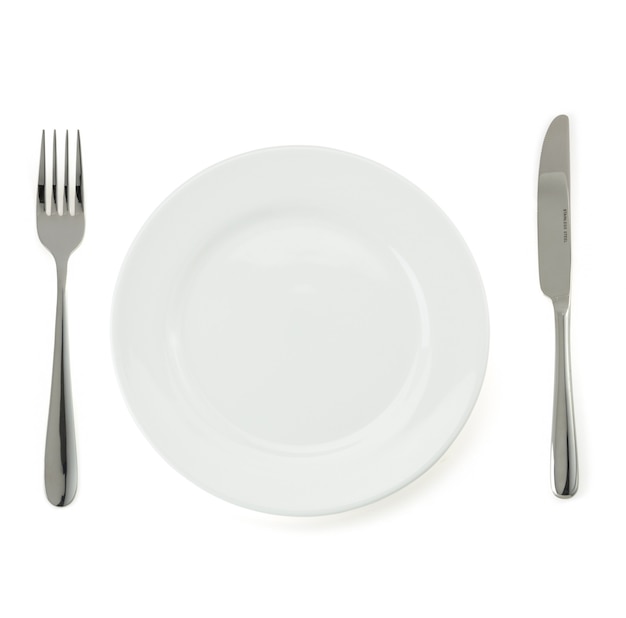 Assiette, couteau et fourchette isolé sur mur blanc