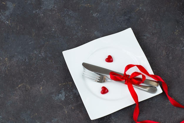 assiette avec couverts et coeurs rouges