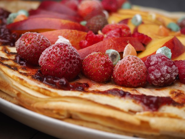 Une assiette de crêpes avec des fruits dessus