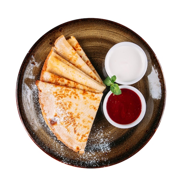 Assiette de crêpes russes avec confiture et crème sure