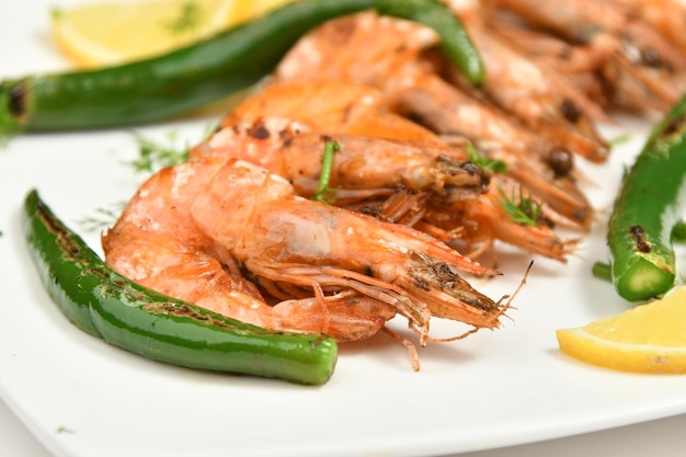 Une assiette de crevettes grillées aux poivrons verts et au citron