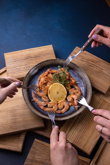 Une assiette de crevettes avec un quartier de citron sur le côté