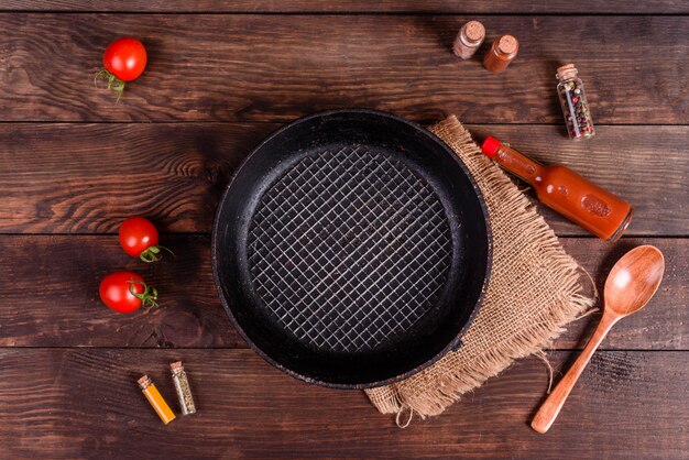 Assiette, cuillère, épices et autres accessoires de cuisine sur un fond en bois foncé