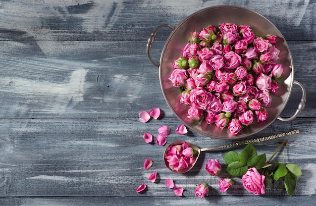 Photo assiette et cuillère vintage avec boutons de rose de thé