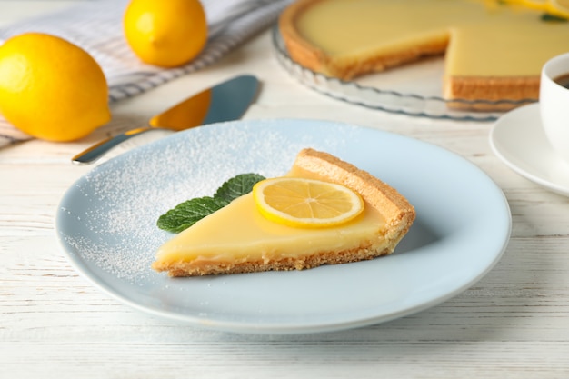 Assiette avec une délicieuse tarte au citron sur fond de bois blanc, Close up