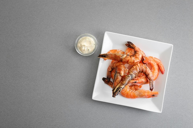 Assiette avec de délicieuses crevettes et sauce dans un bol sur la table