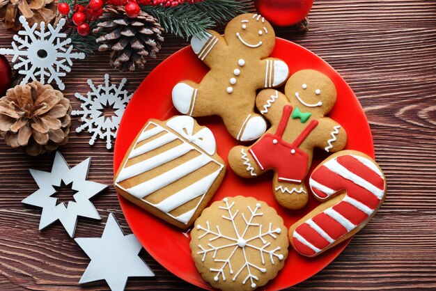 Assiette avec de délicieux biscuits et décor de Noël sur table en bois