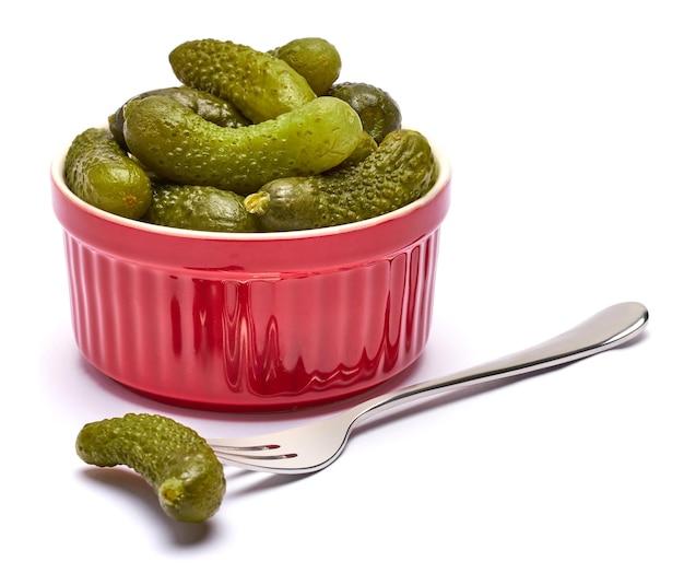 Assiette de délicieux cornichons verts entiers en conserve isolés sur fond blanc