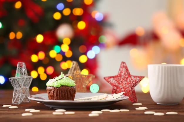 Assiette avec de délicieux cupcakes sur table sur fond flou. Notion de Noël