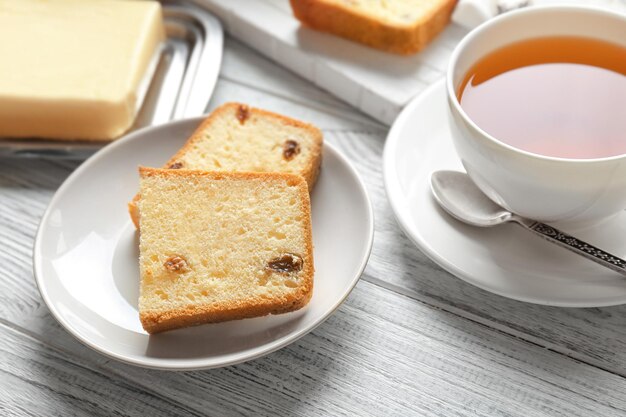 Assiette avec délicieux gâteau au beurre en tranches sur table en bois