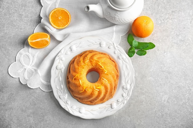 Assiette avec un délicieux gâteau aux agrumes et un zeste d'orange sur une table lumineuse