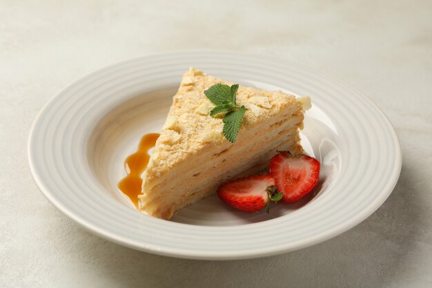 Assiette avec délicieux gâteau Napoléon sur blanc - surface grise