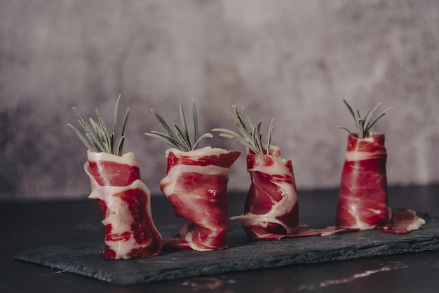 Assiette de délicieux jambon ibérique sur un fond de table en bois. Tranches appétissantes de jambon ibérique. Jambon Ibérique de Bellota.