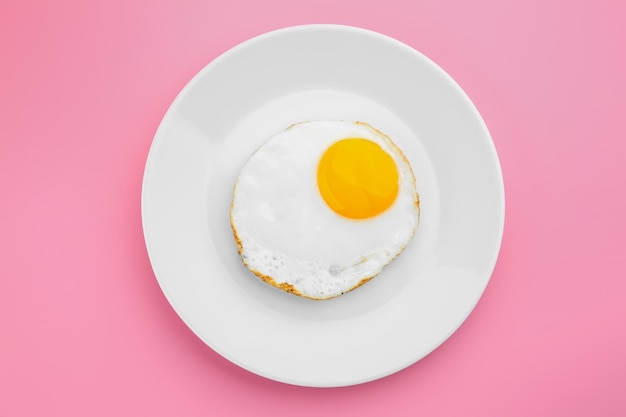 Assiette avec de délicieux œufs au plat sur un fond de couleur