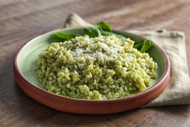 Assiette avec un délicieux risotto aux épinards sur une table en bois