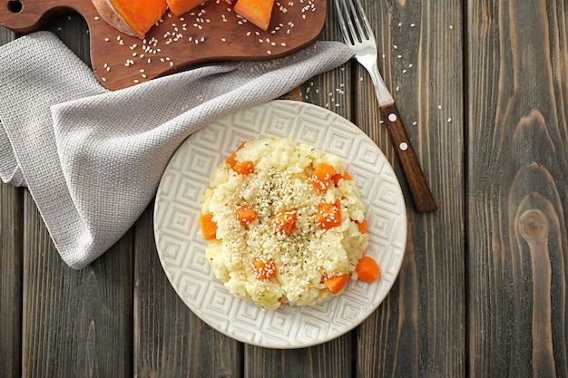 Assiette avec un délicieux risotto à la citrouille sur une table en bois