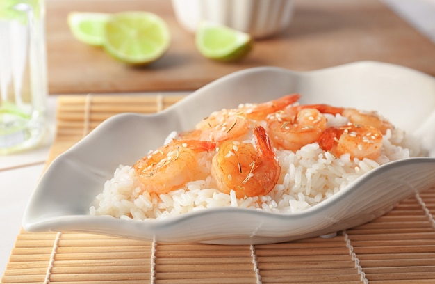 Assiette avec de délicieux riz frit aux crevettes sur la table