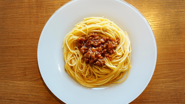 Assiette de délicieux spaghettis bolognaise ou bolognaise avec du bœuf haché salé et de la sauce tomate garnie, vue aérienne