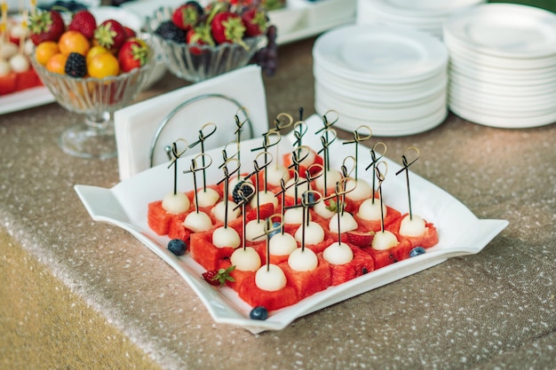 Une assiette de dessert melon et pastèque sur une belle assiette blanche Sur une belle table de buffet