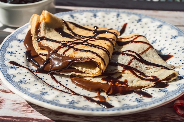 Photo assiette deux galettes ou crêpes exquises fourrées à la crème d'amande recouvertes de fils de chocolat