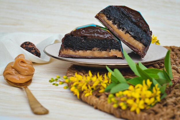 Une assiette avec deux morceaux de gâteau au chocolat et des fleurs.